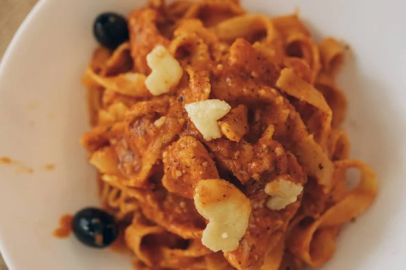 Паста с томатным соусом, сыром и маслинами на тарелке