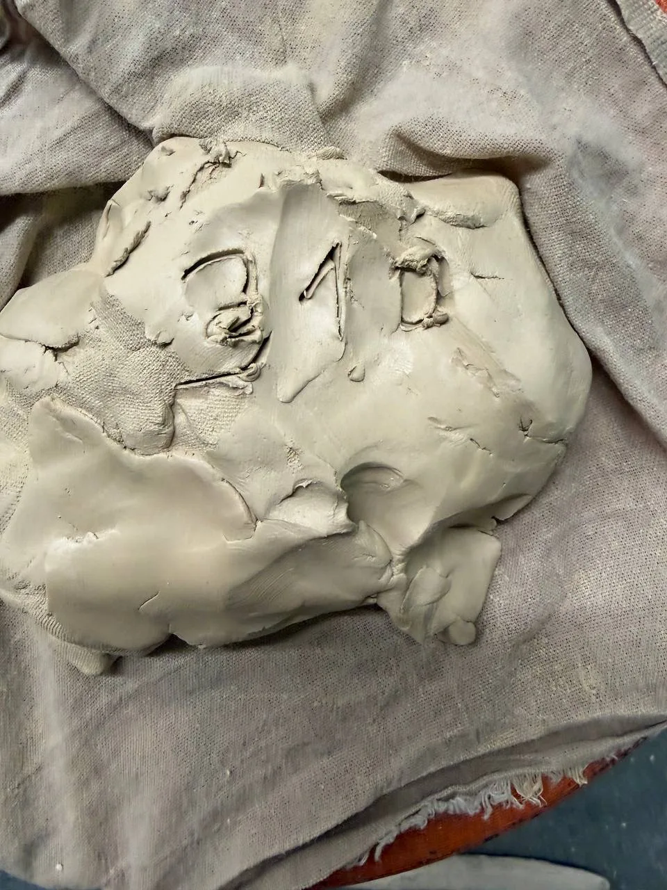 Кусок сырой глины с продавленными цифрами на ткани.