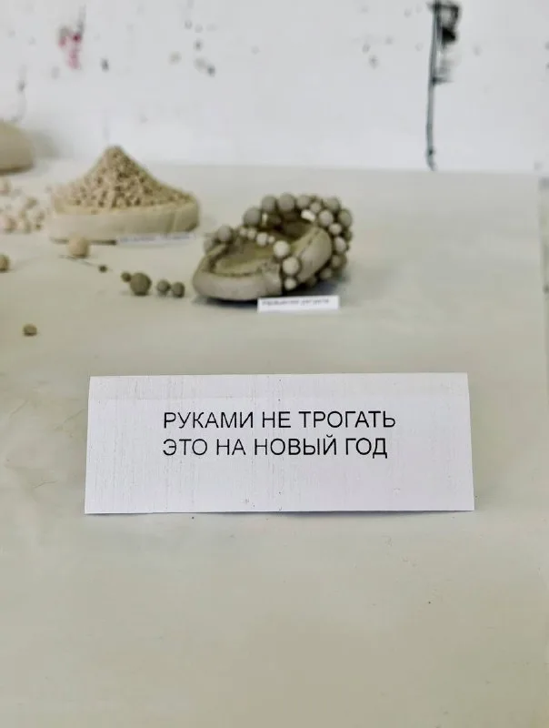 Глиняные керамические изделия на столе и табличка с надписью «Руками не трогать это на Новый год».