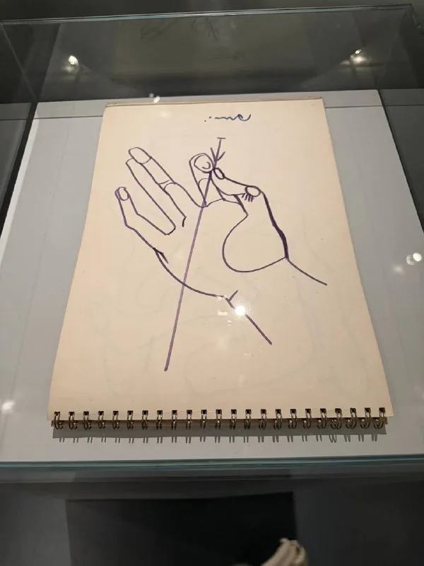 Графический рисунок кисти руки на странице блокнота на пружине.